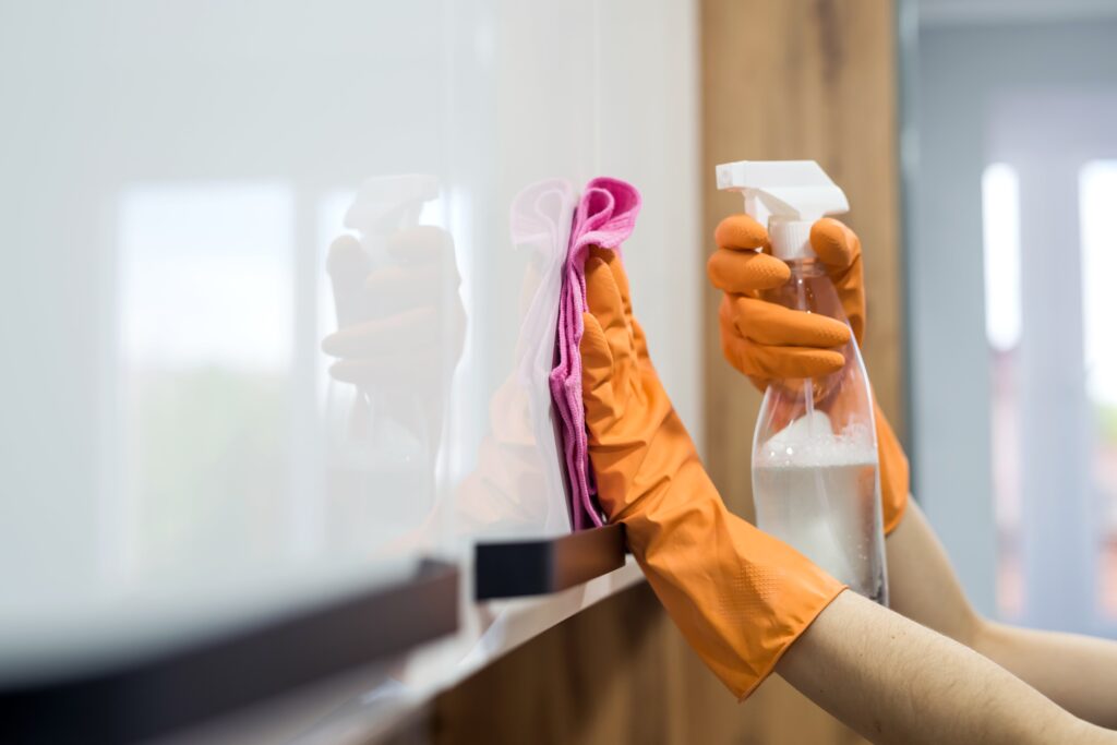 woman-while-cleaning-surface-kitchen-desk-with-sponge-her-rubber-gloves-housework-minse4rf